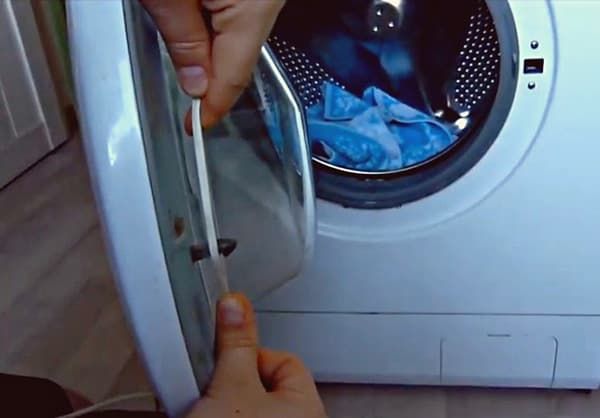 Подцепите разблокировку замка стиральной машины веревкой или проволокой